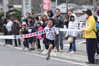 懸命な走りでテープを切る小学生